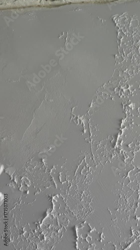 master painter builder creates a pattern on decorative plaster with a spatula and trowel