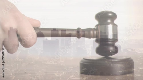 Pale hand swinging wooden gavel onto block executing strike then lifting it above skyline