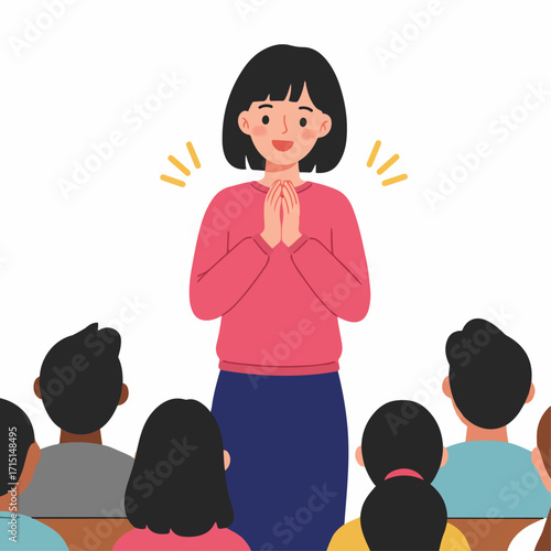 A smiling woman with her hands clasped together in front of her, addressing an audience.
