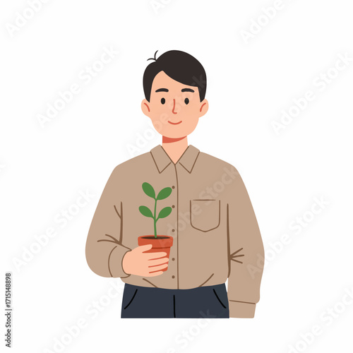 A smiling man in a brown shirt holds a small potted plant with green leaves.