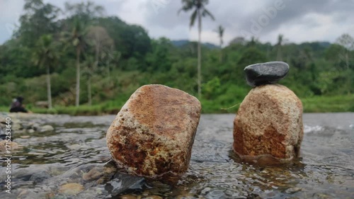 Stone Stacking Zen: A tranquil scene of Zen-inspired stone stacking beside a flowing river, under a cloudy sky. Capturing the perfect balance and the meditative state of nature.