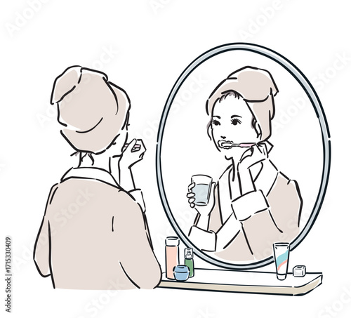 鏡の前に立つバスローブ姿の女性　　歯磨き