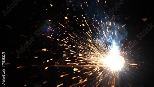 Slow motion welding sparks cascading like fireworks against black background  