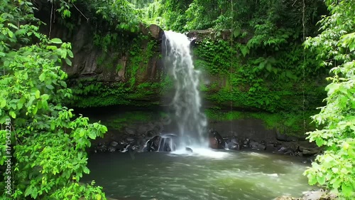 Lush waterfall cascading into a tranquil pool, surrounded by vibrant green foliage.