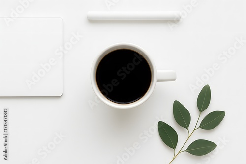 Minimal flat lay composition with cup of black coffee, fresh green leaves, rolled white paper and clean workspace background, perfect for creative design, branding or lifestyle concept