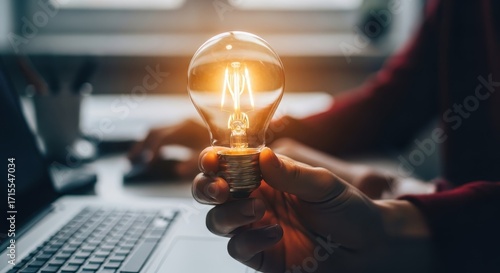 Person holding a glowing light bulb representing a bright idea or innovation