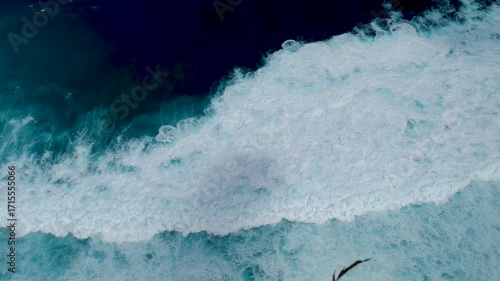 Seascape dark ocean background wave splash on rock. Tropical sea beach in summer seaside outdoor. Water Surface blue wave pattern. Turquoise ocean sea water white wave pattern splashing deep blue sea