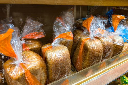Fotografi Freshly packaged loaves of whole grain bread on display in a grocery store aisle