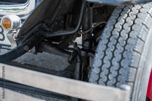 A detailed, close-up shot of the front axle, suspension, and transverse leaf springs on a classic type AA or BB truck