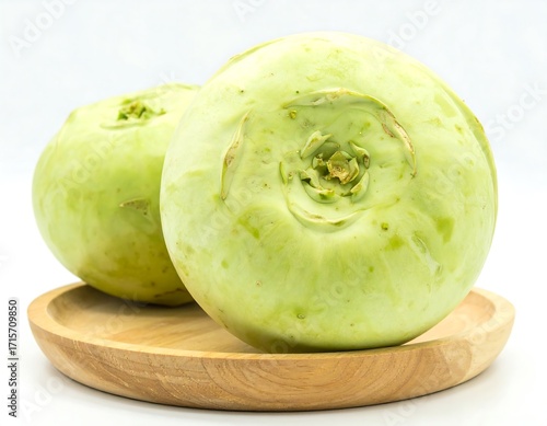 Two round kohlrabi on a wooden plate