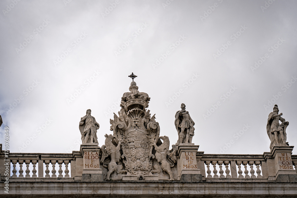 Fototapeta premium Majestic statues and coat of arms embellishing the facade of the Royal Palace in Madrid, Spain