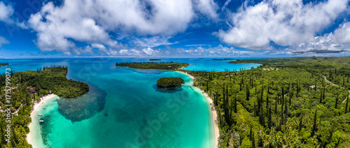 An aerial drone view of the famous Kanumera and Kuto bays on the Isle of Pines, New Caledonia. The sacred Rocher de Kanumera sits in the pristine turquoise water of the lagoon