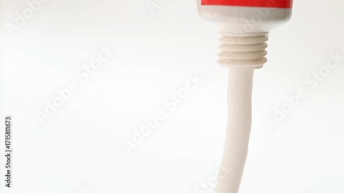 White cream coming out of a tube on white background, medical, cosmetic or skincare product