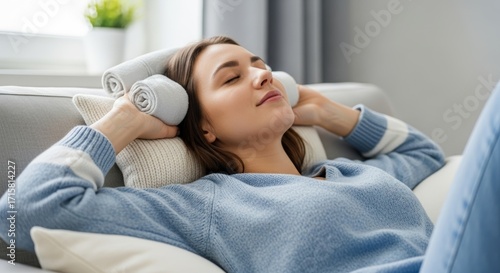 Woman relaxes peacefully on sofa in bright living room