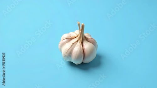 Watch fresh garlic rotate in slow motion against a vibrant sky blue backdrop, perfect for food blogs, culinary videos, and health-focused content