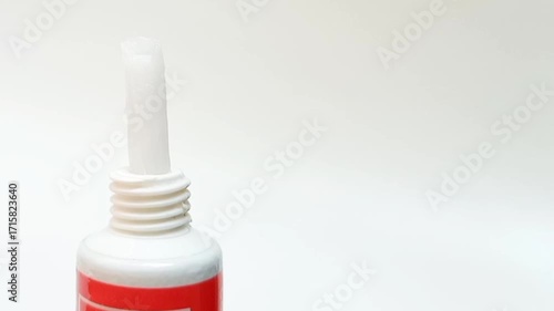 White cream coming out of a tube on white background, medical, cosmetic or skincare product