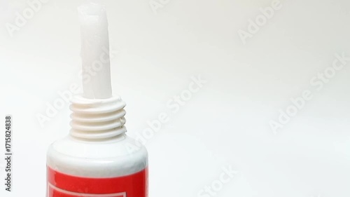 White cream coming out of a tube on white background, medical, cosmetic or skincare product