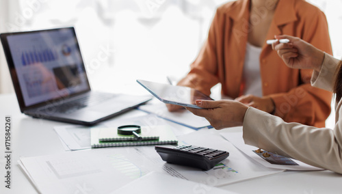 Team of business or accountant hand holding pen working on calculator to calculate business data, accountancy document and laptop computer at office, business concept
