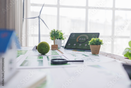 esg small green ball symbolizing earth ESG environment, social,governance recycle sign on laptop screen with carbon free chart board in office
