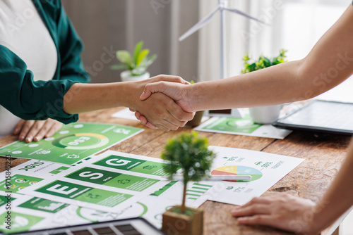 Close up of business people shaking hands over ESG strategic commitment workshop, SDGs report, global warming, green finance investment eco friendly and net zero waste in boardroom training building.

