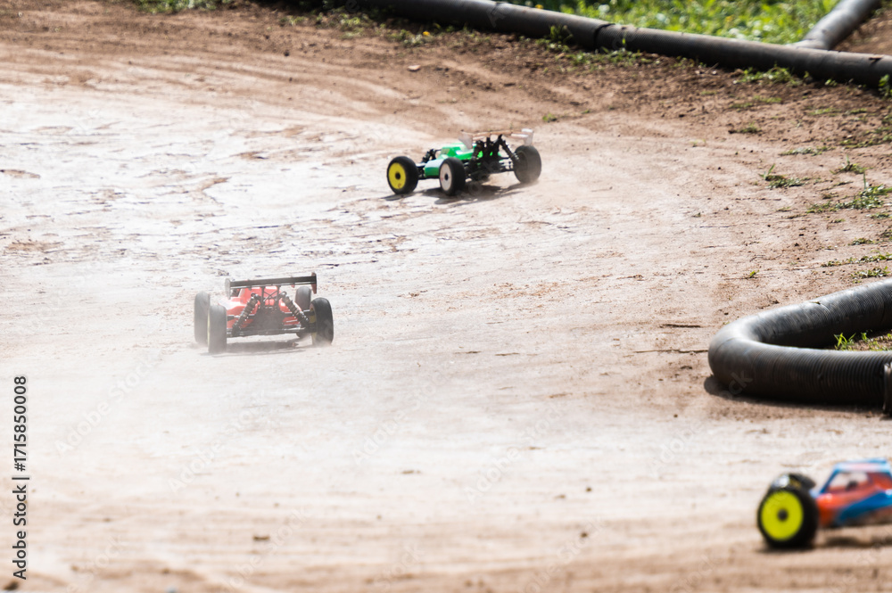 Obraz premium Radio-controlled cars racing on dirt track raising dust