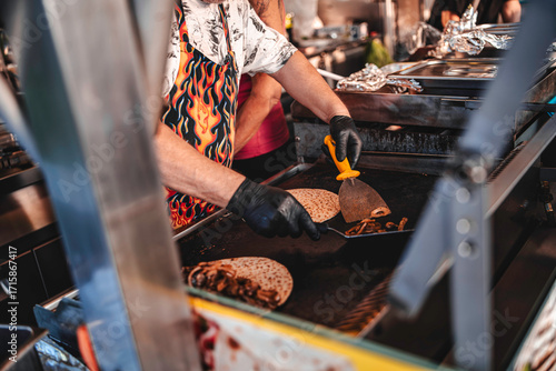 Fototapeta Naklejka Na Ścianę i Meble -  Chef preparing street food quesadillas on a hot griddle