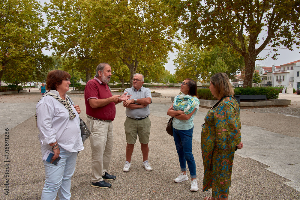 Fototapeta premium A group of retirees listening attentively to an explanation, enjoying a cultural trip in a historic setting.