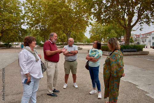 A group of retirees listening attentively to an explanation, enjoying a cultural trip in a historic setting.