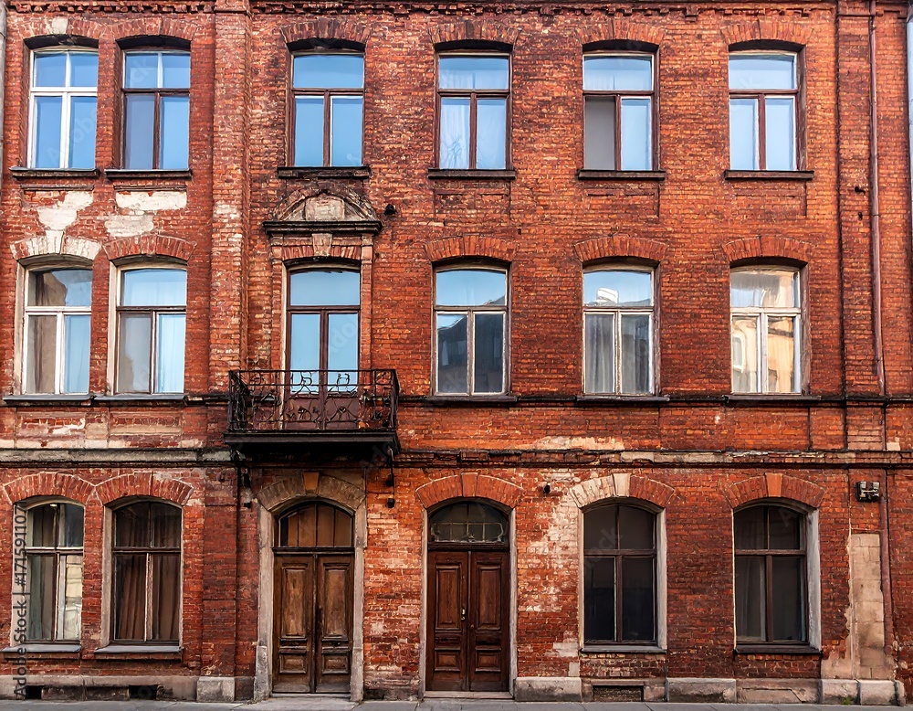 Fototapeta premium Old brick building facade with windows and doors