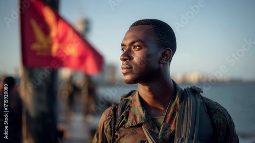Proud african american young male soldier looking into distance with flag behind in military service outdoor setting
