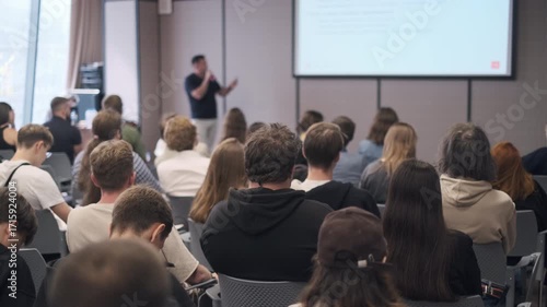 Wallpaper Mural Group of individuals attentively listening to a presenter at a seminar in a modern venue. Torontodigital.ca