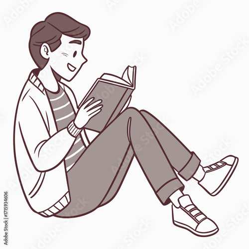 A happy young man sitting cross legged reading a book with a smile on his face
