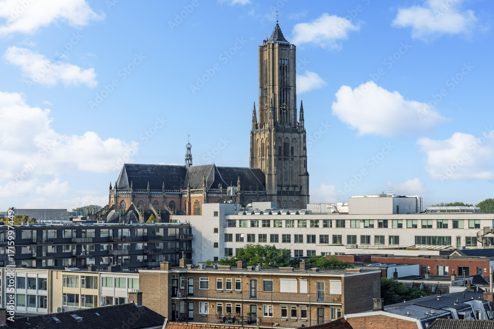 Obraz premium The stunning Eusebius Church stands out in the Arnhem skyline, its historic grandeur contrasting with the surrounding modern city buildings and rooftops.