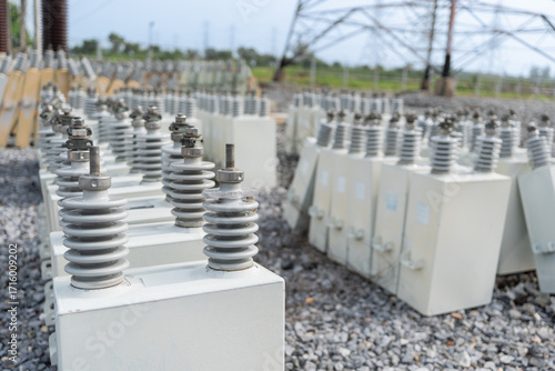Foto Close up of capacitor bank units with ceramic insulators at high voltage electrical substation, equipment for reactive power support, energy storage, and reliable electricity supply