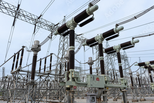 High-voltage power circuit breaker in T-shape configuration at an electric substation. Designed for interrupting fault currents and protecting transmission systems in power infrastructure.