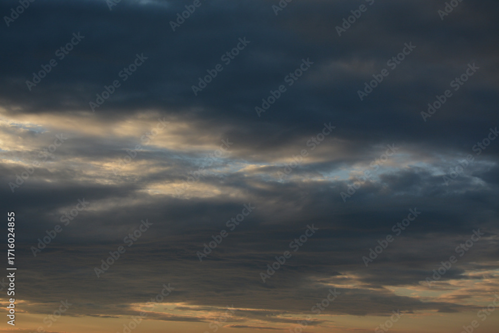 Fototapeta premium Black clouds and blue sky peeking out from behind them