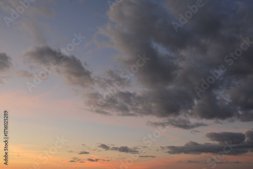 Beautiful evening sky with orange rays of sun and gray clouds