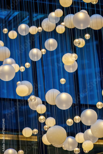 Interior of a modern office building with hanging spherical lamps, featuring a sleek and contemporary business design.