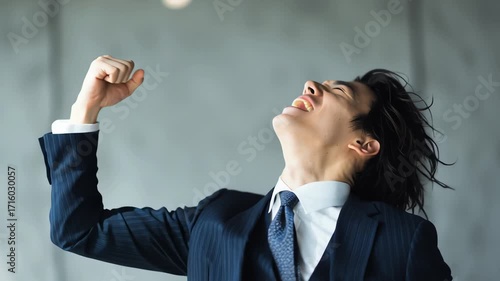 Japanese successful businessman celebrating achievement with fist pump and yelling