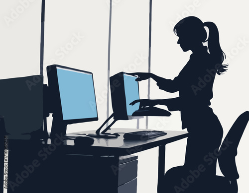 Person working at desk with dual monitors and computer equipment silhouette