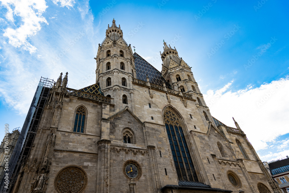 Fototapeta premium Gothic St Stephen's Cathedral With Twin Towers Lit by Bright Blue Sky in Vienna Austria