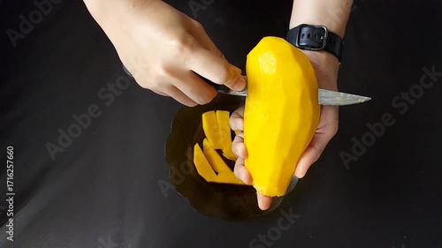 Hands Cutting Ripe Mango Slices on Plate for Tropical Fruit Preparation