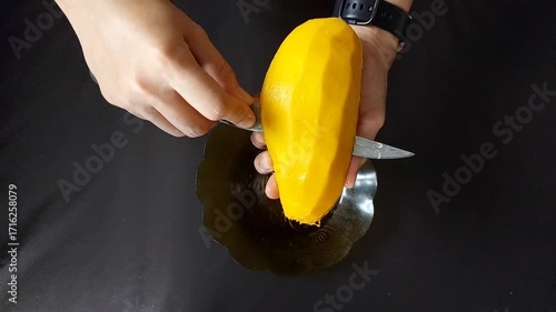 Hands Cutting Ripe Mango Slices on Plate for Tropical Fruit Preparation