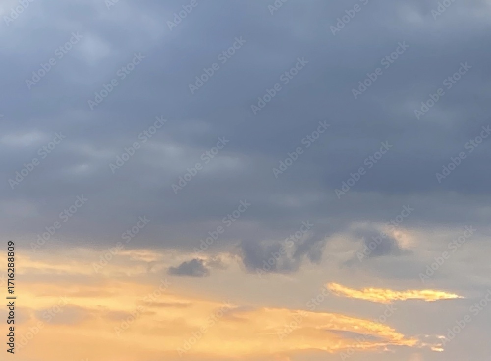 Obraz premium Twilight Sky with Layered Clouds and Warm Light Breaking Through