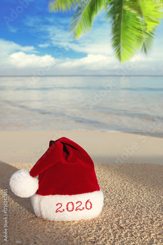 New Year 2026 background with red Santa Claus Hat on Caribbean beach.