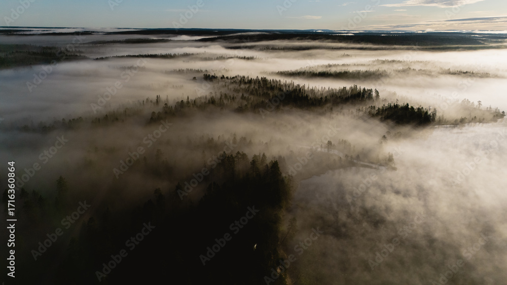 Fototapeta premium Experience the breathtaking beauty of Hossa National Park, Finland during sunrise with fog over the forest