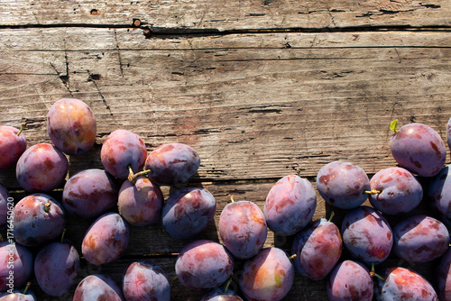 Ripe juicy plums on a wooden table. Organic fruits.