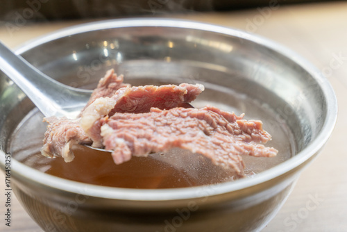 Tableau sur toile A traditional bowl of Tainan fresh beef soup, served with tender slices of beef in a clear flavorful broth