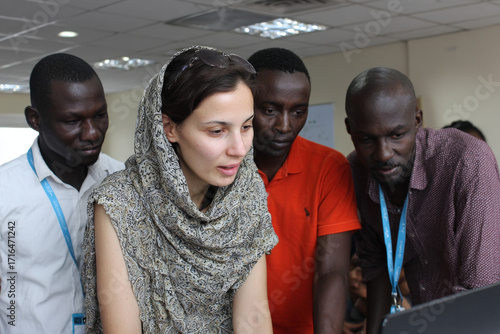 diverse group of migrants receiving assistance from ai program designed to help them acclimate to their new