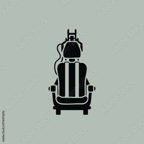 Black silhouette of a dental chair with headrest and attached dental equipment on a muted gray background